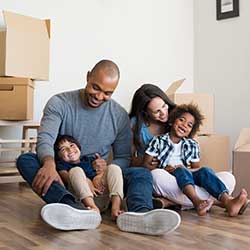 Family with boxes sitting on floor of new home Consumer Loan
