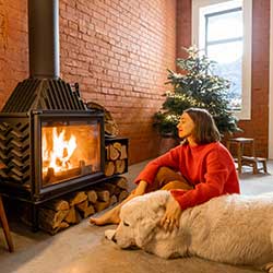 Woman enjoying a fire with her dog knowing her IRA account will be safe at Carter Bank.